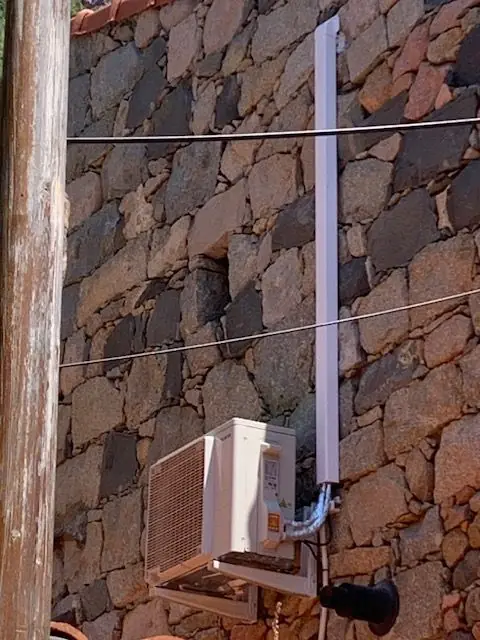 Unité extérieure sur un mur en pierre, liaisons sous goulotte
